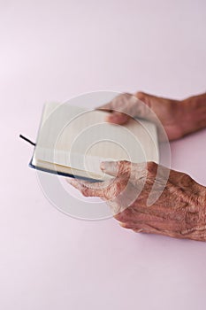 senior omen hand turning a pager of a diary