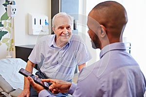 Senior Patient And Doctor Have Consultation In Hospital Room