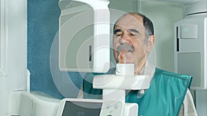 Senior patient doing examination of teeth by using panoramic and cephalometric X-Ray scanner photo