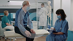 Senior patient having conversation with female nurse at checkup visit