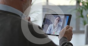 Senior patient having a video chat consultation with his doctor