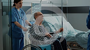 Senior patient leaving hospital ward in wheelchair photo