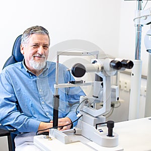 Senior patient sitting the exmanination chair , before having his eyes examined by an eye doctor