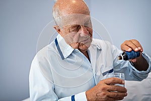 Senior patient taking medicine drops for sleep