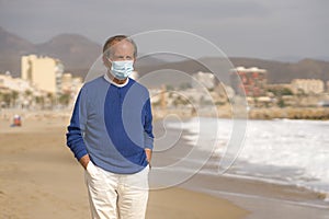 Senior pensioner relaxed in beach during new normal - retired old man on his 70s wearing surgical mask against covid19 walking at