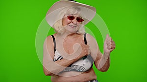 Senior pensioner woman tourist in swimsuit bra, red sunglasses and hat dancing celebrating, smiling