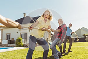 Senior people competing in pulling ropes