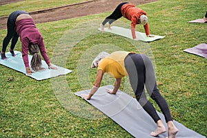 Senior people doing yoga class at city park - Focus on african woman