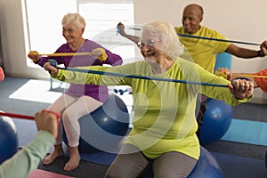 Senior people exercising with resistance band in fitness studio