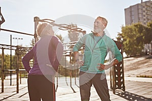 Senior people and gymnastics. Active happy mature family couple in sportswear doing morning exercises together, warming