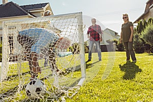 Senior people having fun playing football in the backyard