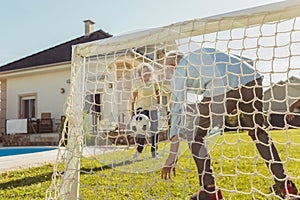 Senior people having fun playing football in the backyard