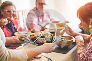 Senior people having vegetarian lunch at home - Mature friends eating bbq vegetables,fresh salads and drinking red wine - Healthy