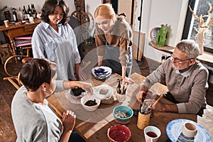 Senior people making clay dishes and glaze it art studio