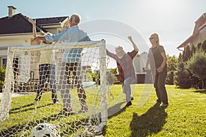 Senior people playing football at the backyard