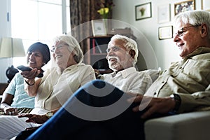 Senior people watching television together