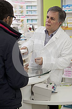 Senior Pharmacist Showing Drug In Pharmacy To a Customer