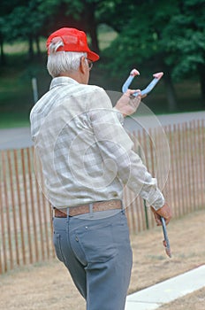 A senior playing a game of horseshoes