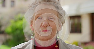 Senior portrait, smile and face on an elderly woman standing outside feeling happy and content in retirement outside old