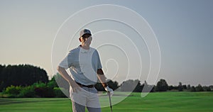 Senior posing golf course outdoors. RIch man looking camera on golfing field.