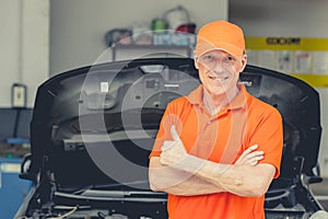 Senior Professional look Car Mechanic Standing in Garage. Portrait Happy Smiling Caucasian Adult Male in Auto Service Thumbs up