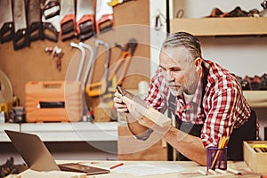 Senior professional male caucasian diy wood working making home furniture in workshop, home renovate