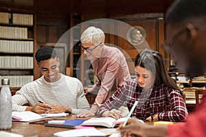 Senior professor helping group of students