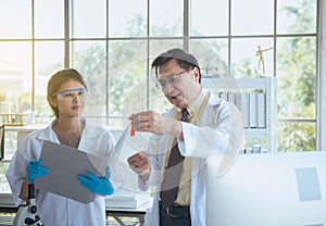 Senior professor teaching medical student for analyzing data research information together in the laboratary