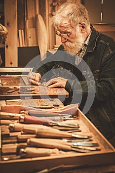 Senior restorer working with antique decor element in his workshop