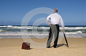 Senior retired business man dreaming of retirement freedom on a beach.