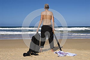 Senior retired business man undressed standing on a tropical beach, retirement freedom concept