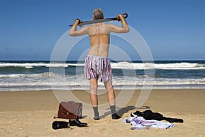 Senior retired businessman undressing and relaxing on a beach, retirement freedom concept