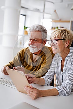 Senior retired couple learn about computer and online support.