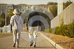Senior retired couple wearing sportswear walking along a path in the park having sport workout.
