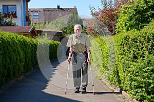 Senior retired man walking on crutches