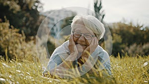 Senior retired woman enjoying the sunny autumn day in the park