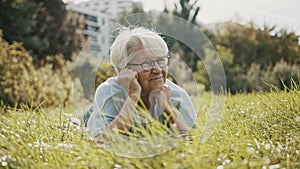 Senior retired woman enjoying the sunny autumn day in the park