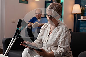 Senior retired woman looking at digital tablet gadget