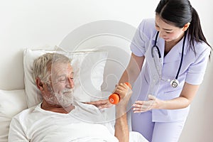 Senior retirement man doing dumbbell fitness training with physiotherapist