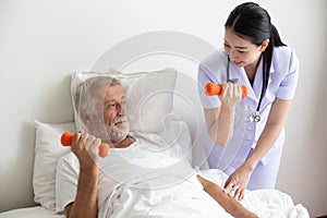 Senior retirement man doing dumbbell fitness training with  physiotherapist