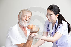 Senior retirement man doing dumbbell fitness training with  physiotherapist