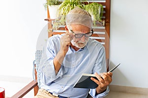 Senior retirement man happy reading book at home