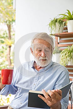 Senior retirement man happy reading book at home