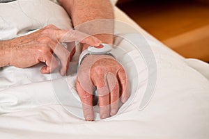 Senior with rufhilfe emergency phone in bed