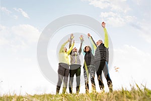 Senior runners outdoors, resting, hands in the air.