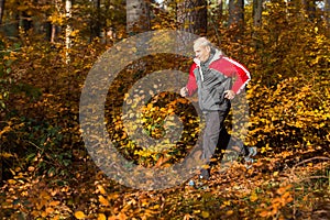 Senior running in the forest in autumn