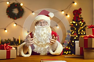 Senior Santa gesticulating during chatting and congratulating people online