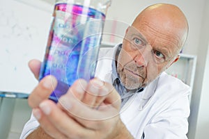 senior scientist holding flask