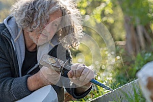 Senior sculptor carving into stone