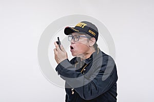 A senior security guard barks orders on his walkie-talkie or handheld transceiver. A strict superior giving commands. Isolated on photo